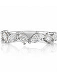This 18k white gold band features 7 mixed shaped diamonds set scattered around the band that total 0.90ctw. This ring measures as a size 6.50.