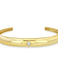 14k yellow gold cuff bracelet from Zoë Chicco features a single star-set diamond that totals 0.10ctw and at the center of the slim cuff. Shown on a white background.