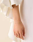 Yellow gold bracelet chain with five stations of hand engraved beads. Lobster clasp with chain extender. On a white background.