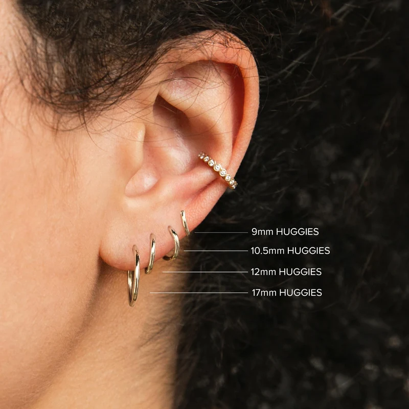 These 14k yellow gold earrings from Zoe Chicco measure 10.5mm in diameter with a hinged closure. Shown on a model with a size comparison of 9mm, 12mm, and 17 mm versions of the earring.