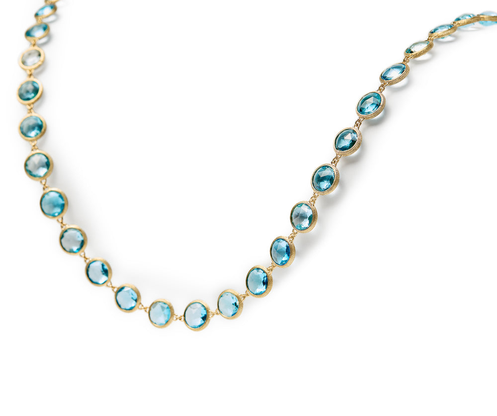 18K yellow gold station necklace featuring bezel-set, rose-cut round blue topaz gemstones arranged in a continuous line with a lobster clasp. Displayed on a white background.