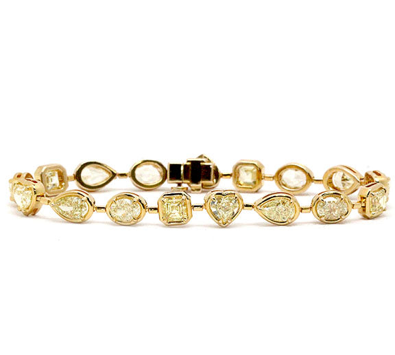 This 18k yellow gold bracelet from Norman Silverman features 17 bezel-set, mixed-shape yellow diamonds stations that total 11.97ctw.