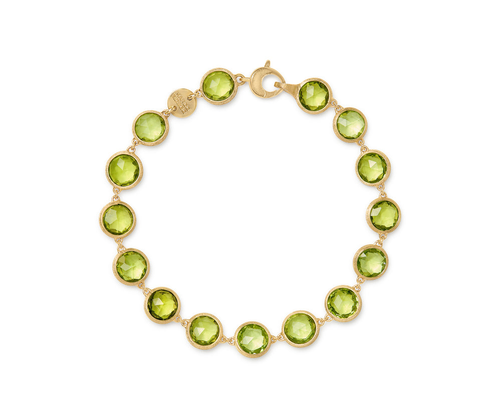Yellow gold bracelet with bezel set peridot stones set in a line on a white background.
