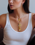 This 18K yellow gold round pendant from Penny Preville features a single round pink sapphire totaling 0.35ctw, accented by round and emerald-cut diamonds totaling 0.45ctw. The pendant is finished with a bail, allowing it to be attached to different necklaces.