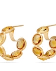 18K yellow gold hoop earrings featuring bezel-set, rose-cut round yellow quartz gemstones arranged in a continuous line. Displayed on a white background.