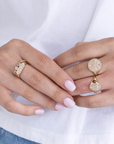 This 14k yellow gold signet ring from Zoe Chicco features an flat oval design with pear, marquise, princess, and round diamonds that total 0.25ctw. This ring measures 6.5.