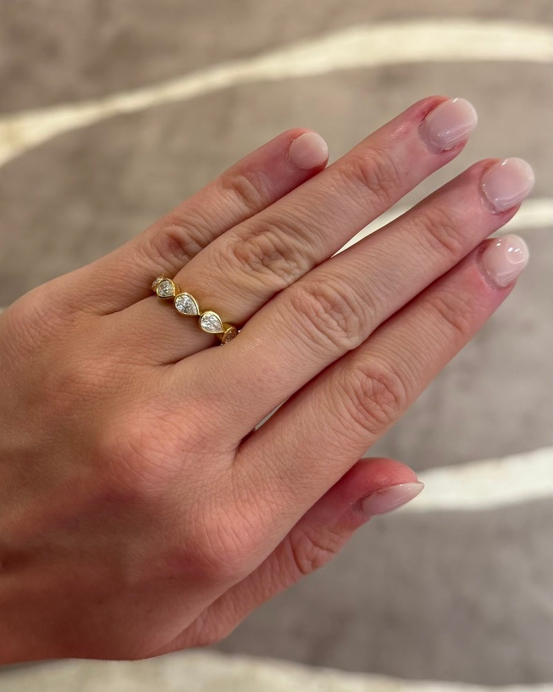 This 18k yellow gold band features five bezel set pear diamonds that total 1.01ctw. This ring measures as a size 6.5.