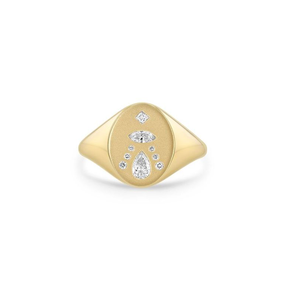 This 14k yellow gold signet ring from Zoe Chicco features an flat oval design with pear, marquise, princess, and round diamonds that total 0.25ctw. This ring measures 6.5.
