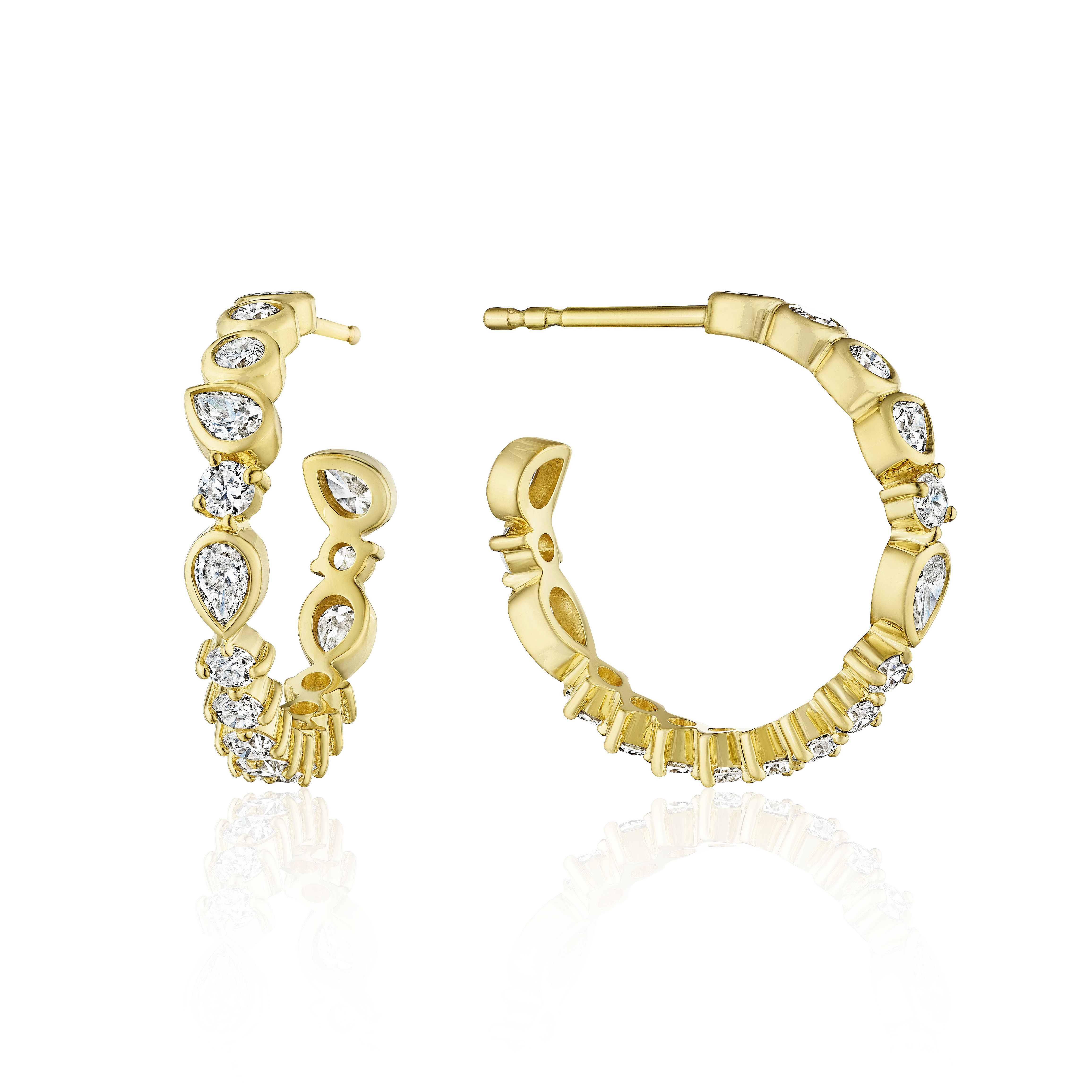 A pair of gold hoop earrings with pear-cut and round clear diamond stones, shown from the front and side on a white background with a soft reflection.