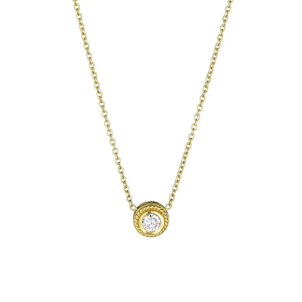 A delicate gold chain necklace featuring a round pendant with a textured gold border and a central clear gemstone, shown against a plain white background.