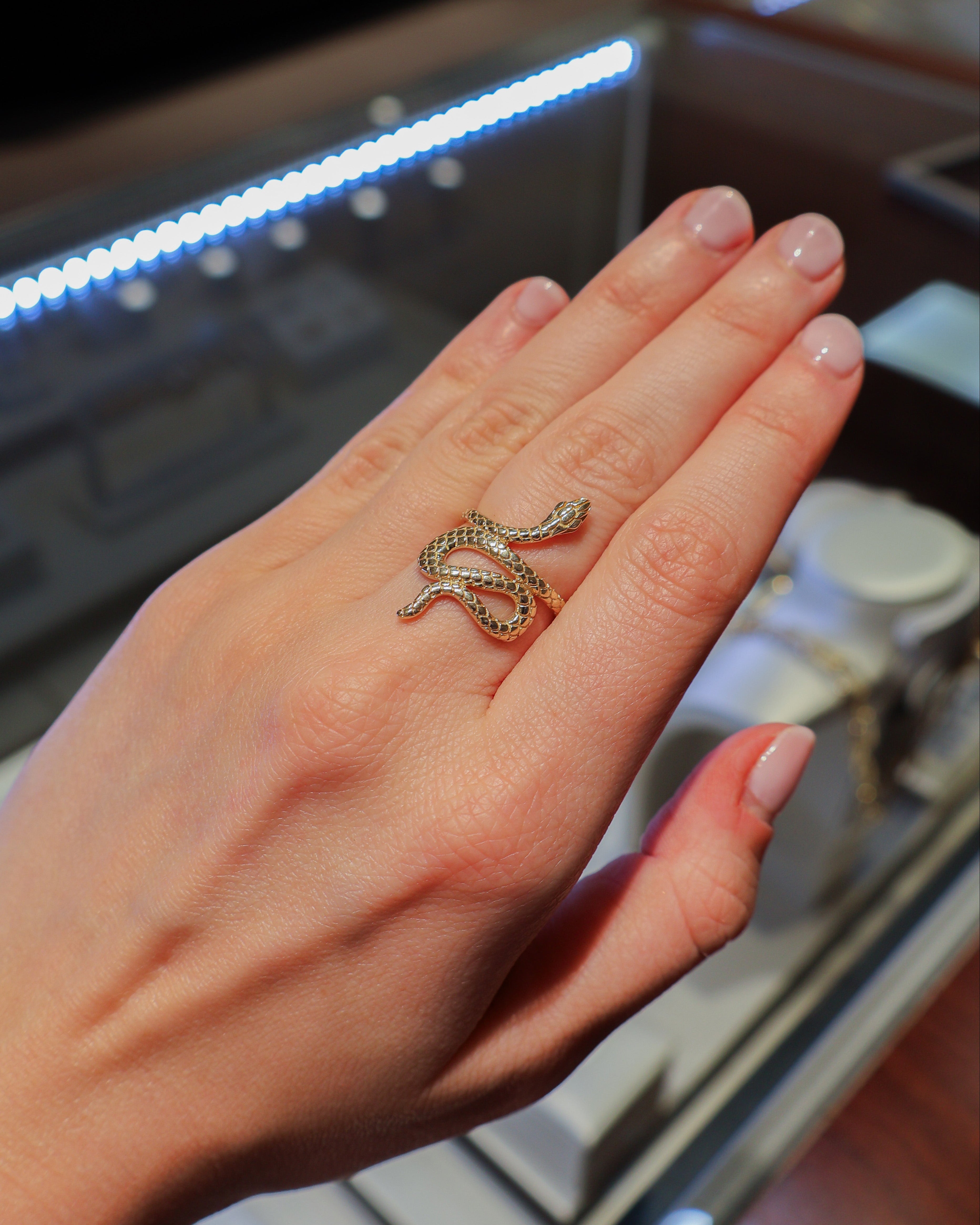 yellow gold ring in the design of a snake on a hand.
