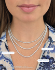Model wearing three necklaces, displaying a small, medium, and large diamond necklace set in white gold.