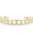 14k yellow gold bangle features an open cuff design and bezel set diamonds that total 0.60ctw. Shown on a white background.