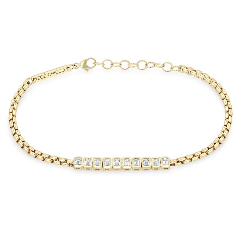 This 14k yellow gold bracelet from Zoe Chicco features a line of 10 bezel set emerald cut diamonds that total 0.96ctw. The diamonds are attached to a medium box chain that measures 6 inches in length with an adjustable chain extender. Shown on a white background.
