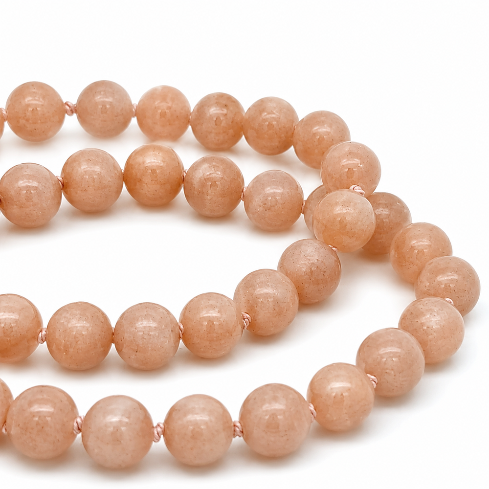 This beaded necklace features a strand of orange moonstone beads that measure 8mm in diameter each. The 16 inch strand is finished with a magnetic ball clasp.
