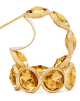 18K yellow gold hoop earrings featuring bezel-set, rose-cut round yellow quartz gemstones arranged in a continuous line. Displayed on a white background.