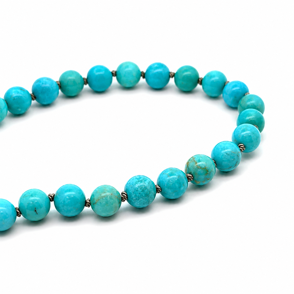 This beaded necklace features a strand of turquoise stone beads that measure 8mm in diameter each. The 16 inch strand is finished with a sterling silver magnetic ball clasp.
